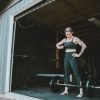 Woman with tattoos working out in garage gym