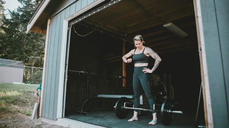 Woman with tattoos working out in garage gym