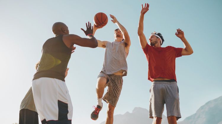 three men playing basketball