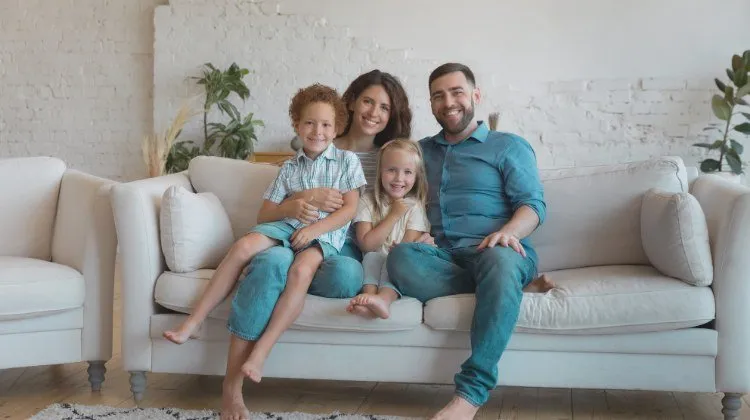 family of four sitting on couch in living room