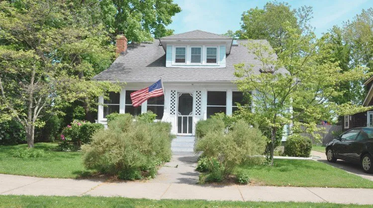home with screened porch and American flag