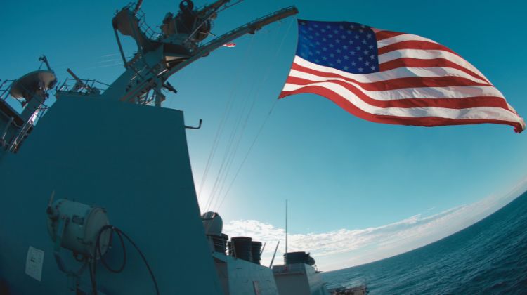 US Navy ship with flag flying