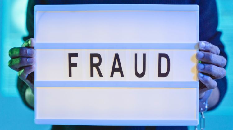 man holding sign that says fraud