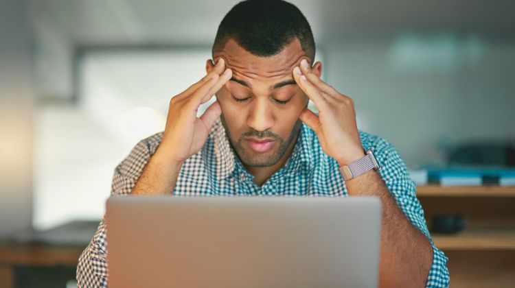 man feeling stressed at computer