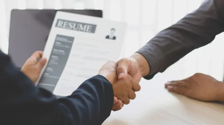 two people shaking hands at a job interview