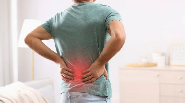 man holding lower back with red added for emphasis of pain