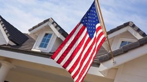 American flag in front of home with blue sky