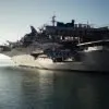 gray Navy aircraft carrier on body of water