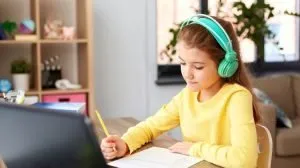 child wearing green headphones learning at home