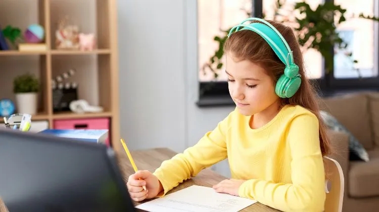child wearing green headphones learning at home